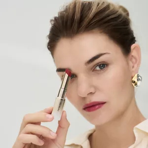 Close up of woman holding Moisture Intense Lipstick and Lipstick Holder Gold creating a chic look